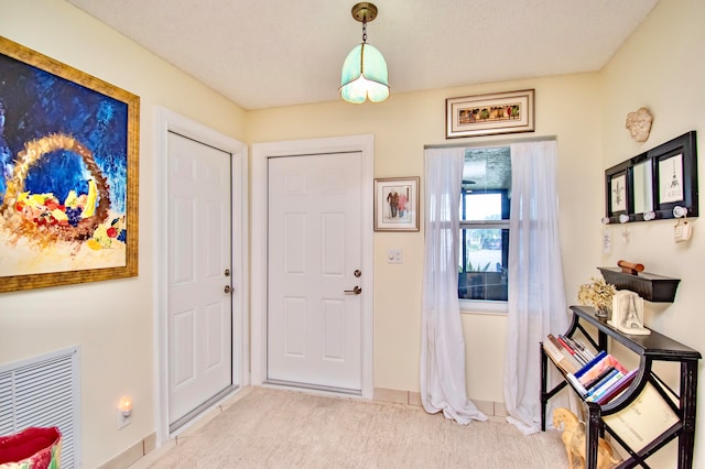 carpeted entrance foyer with a textured ceiling