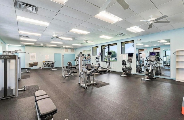 exercise room featuring ceiling fan and a drop ceiling