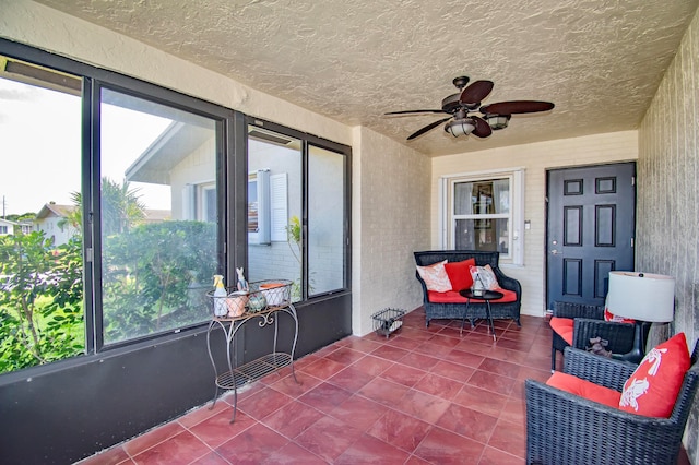 sunroom / solarium featuring ceiling fan