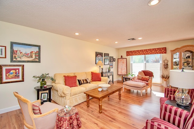 living room featuring light hardwood / wood-style floors and a textured ceiling