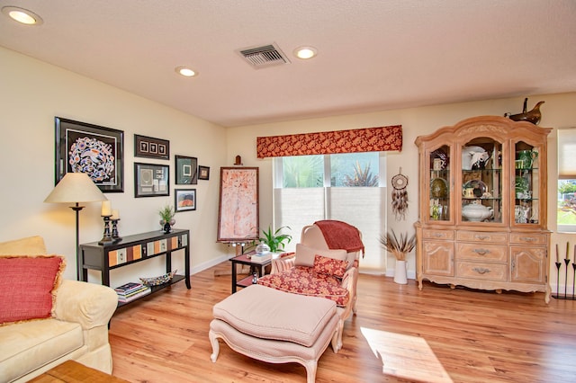 sitting room with light hardwood / wood-style floors and a textured ceiling