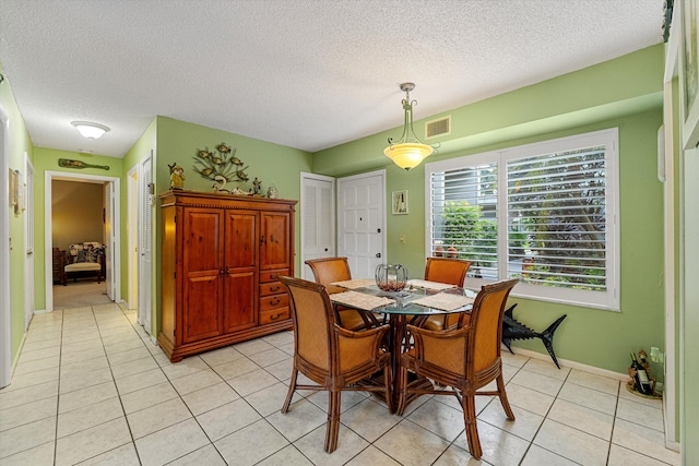 dining room with a textured ceiling and light tile patterned floors