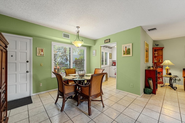 tiled dining space featuring a textured ceiling