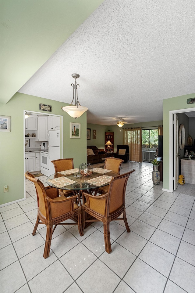 dining room with a textured ceiling, light tile patterned floors, and ceiling fan