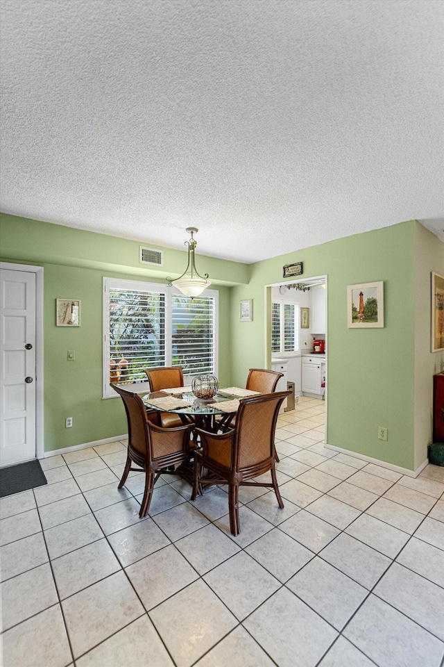 dining room featuring a textured ceiling and light tile patterned floors