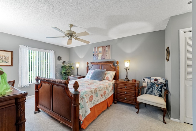 carpeted bedroom featuring a textured ceiling and ceiling fan