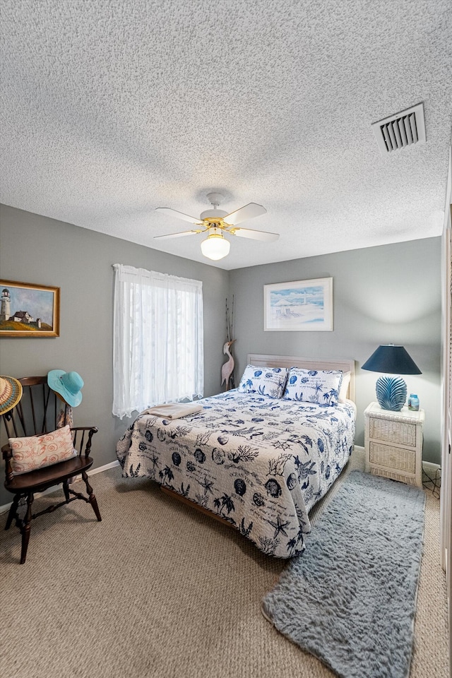 bedroom with ceiling fan, carpet flooring, and a textured ceiling