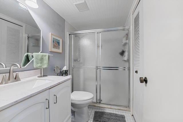 bathroom featuring vanity, toilet, tile patterned floors, and an enclosed shower