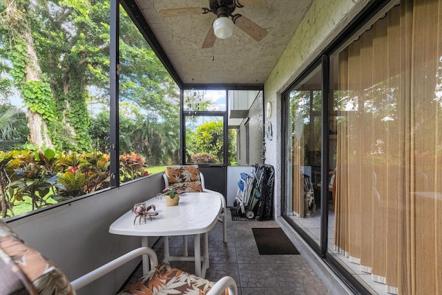 unfurnished sunroom with ceiling fan