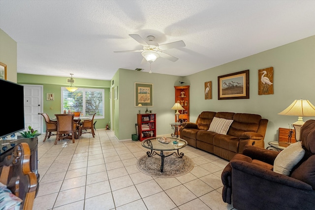 living room featuring a textured ceiling, light tile patterned floors, and ceiling fan