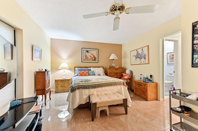 bedroom with ensuite bathroom, ceiling fan, and a textured ceiling