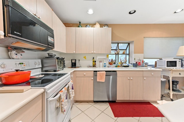 kitchen featuring light brown cabinets, white appliances, and light tile patterned flooring