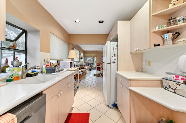 kitchen featuring light tile patterned floors, white appliances, light brown cabinetry, and sink