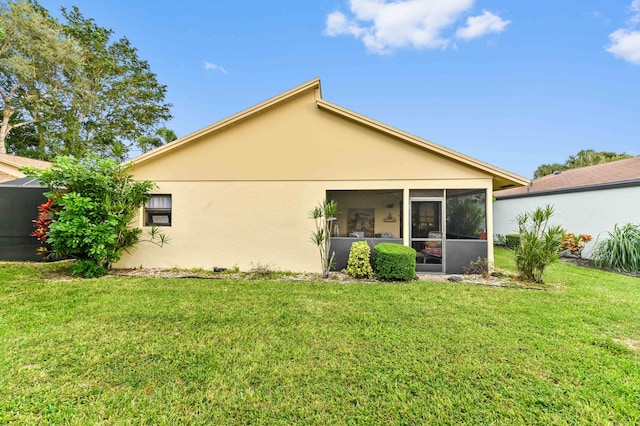 rear view of house with a sunroom and a yard