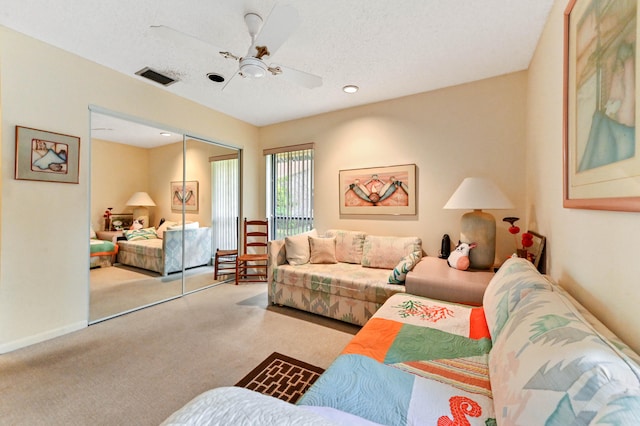 carpeted living room featuring a textured ceiling and ceiling fan