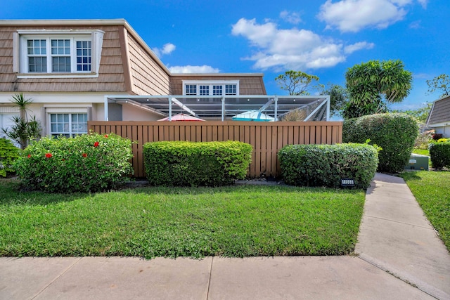 view of front of property featuring a lanai and a front yard