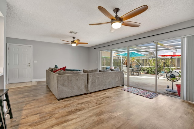 living room featuring a wealth of natural light, a textured ceiling, and hardwood / wood-style flooring