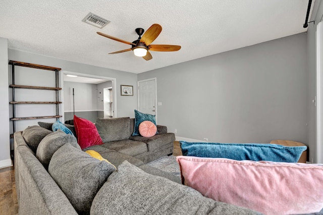 living room with a textured ceiling and ceiling fan