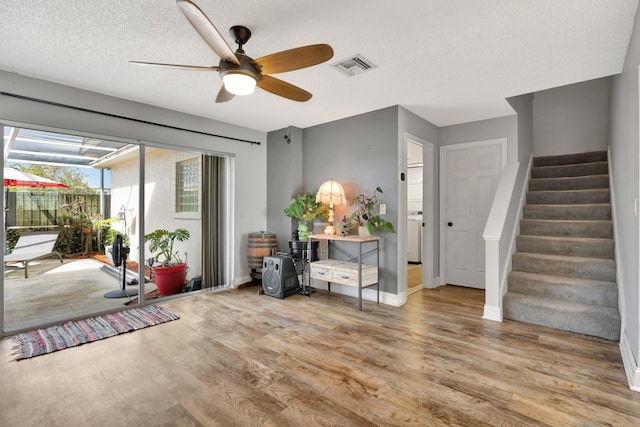 interior space with a textured ceiling, hardwood / wood-style floors, and ceiling fan