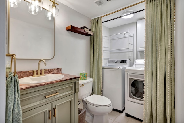 bathroom featuring toilet, separate washer and dryer, vanity, and tile patterned floors