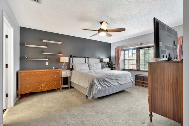 bedroom with a textured ceiling, light carpet, and ceiling fan