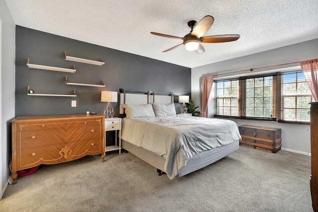 carpeted bedroom featuring a textured ceiling and ceiling fan