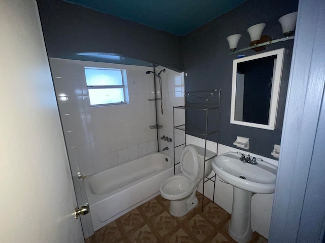 bathroom featuring tiled shower / bath and toilet