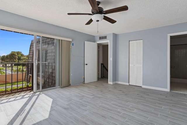 unfurnished bedroom featuring light wood-type flooring, a textured ceiling, and access to outside