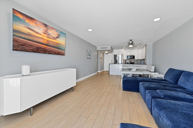 living room with light wood-type flooring and ceiling fan