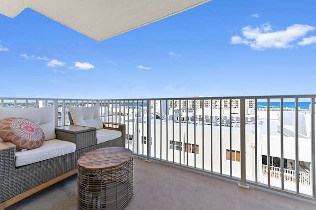 balcony featuring a view of the beach and a water view