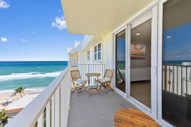 balcony featuring a water view and a beach view