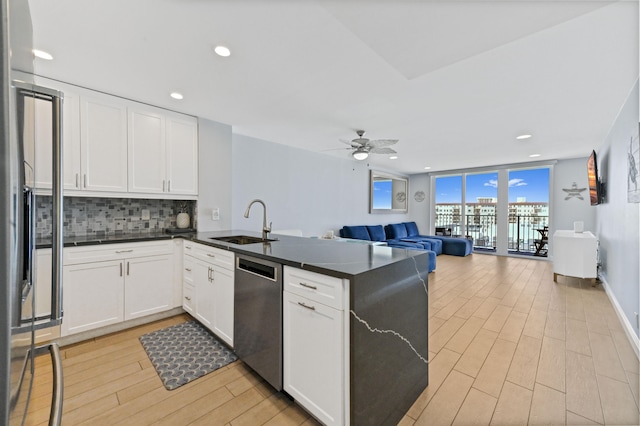 kitchen featuring light hardwood / wood-style flooring, white cabinetry, stainless steel dishwasher, and sink