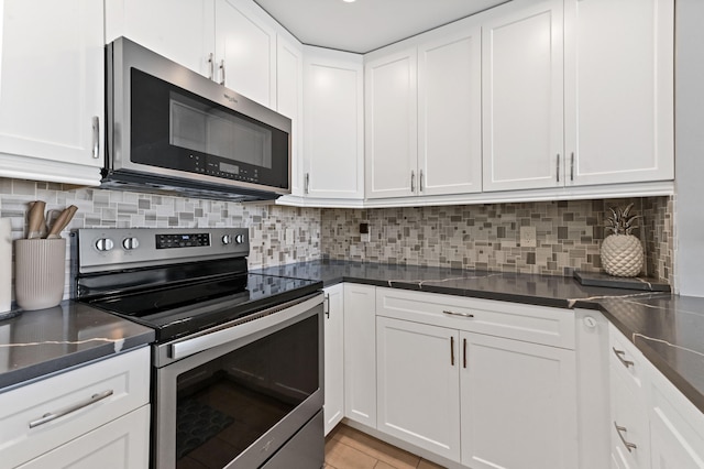 kitchen featuring backsplash, appliances with stainless steel finishes, and white cabinets