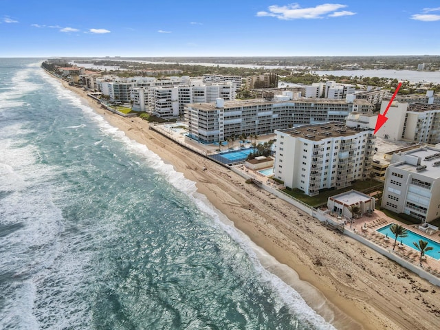 bird's eye view with a water view and a beach view