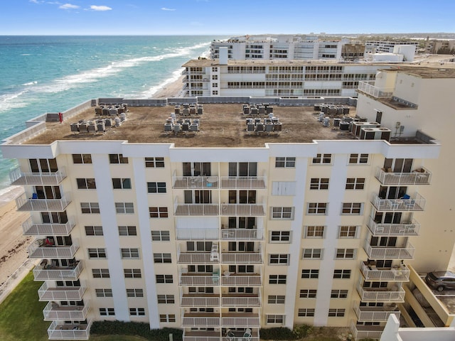 view of building exterior featuring a water view and a view of the beach