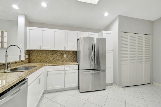 kitchen featuring white cabinetry, sink, stainless steel appliances, and light stone counters