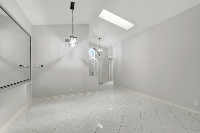 tiled empty room with lofted ceiling with skylight and an inviting chandelier