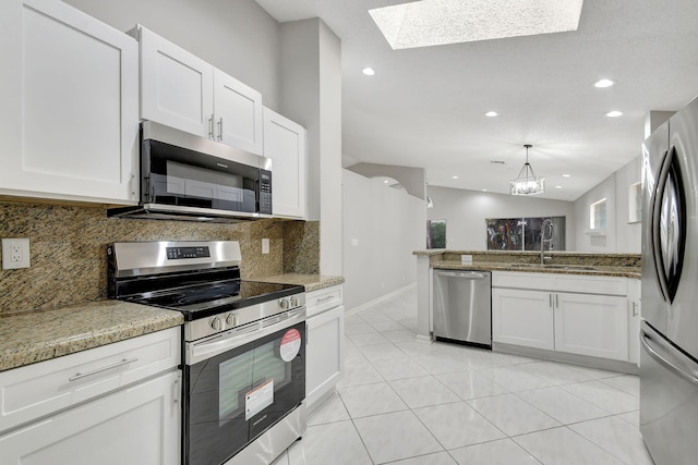 kitchen featuring white cabinets, light tile patterned flooring, stainless steel appliances, and tasteful backsplash