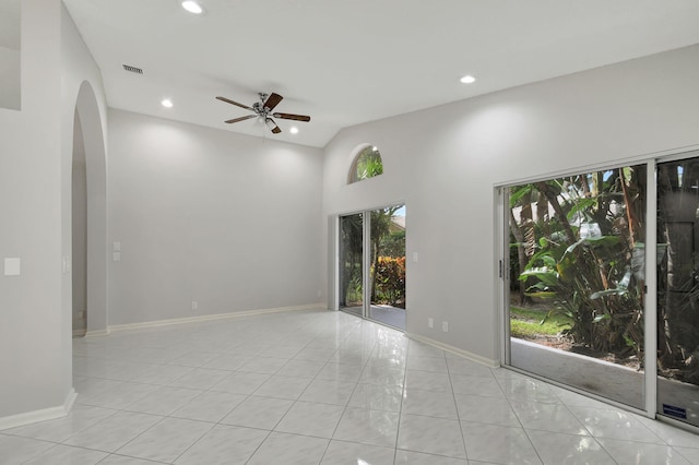 unfurnished room with ceiling fan, light tile patterned floors, and high vaulted ceiling