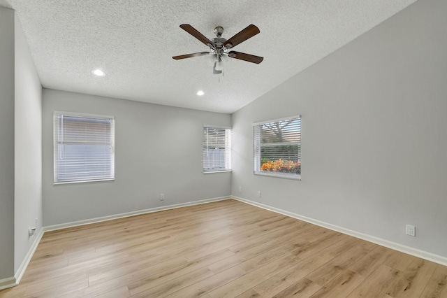 unfurnished room with a textured ceiling, light wood-type flooring, ceiling fan, and lofted ceiling