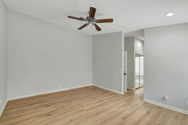 spare room with ceiling fan, a textured ceiling, and light wood-type flooring