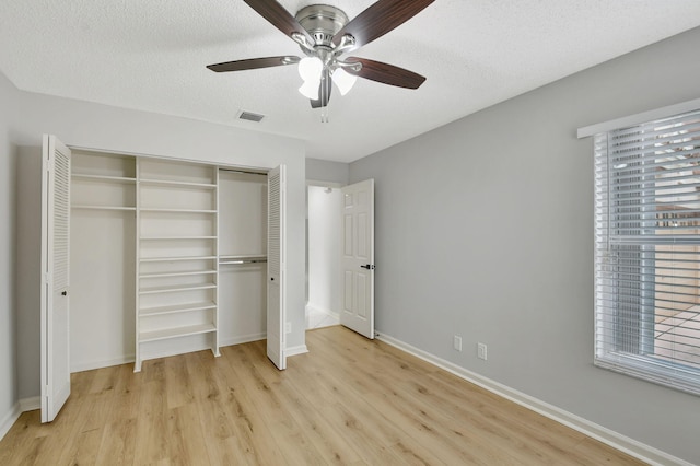 unfurnished bedroom with ceiling fan, light hardwood / wood-style flooring, and a textured ceiling