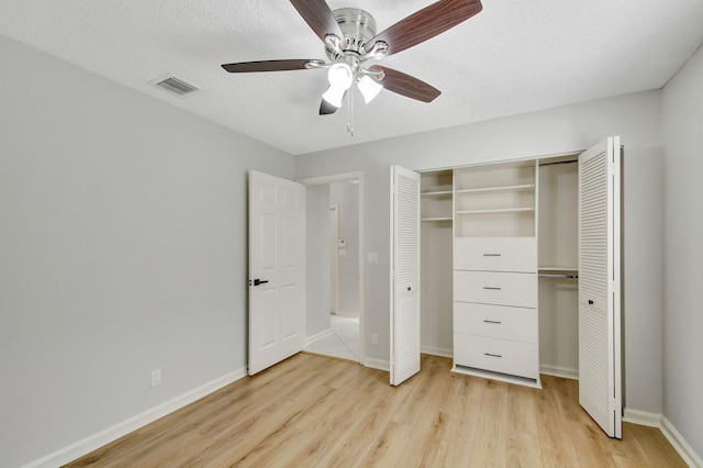 unfurnished bedroom featuring a textured ceiling, light wood-type flooring, a closet, and ceiling fan