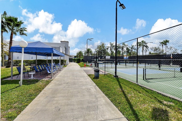 view of tennis court featuring a lawn