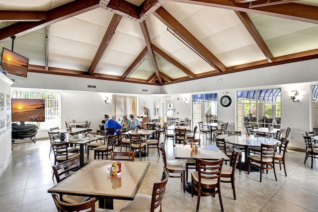 dining area featuring beam ceiling, light tile patterned floors, and high vaulted ceiling