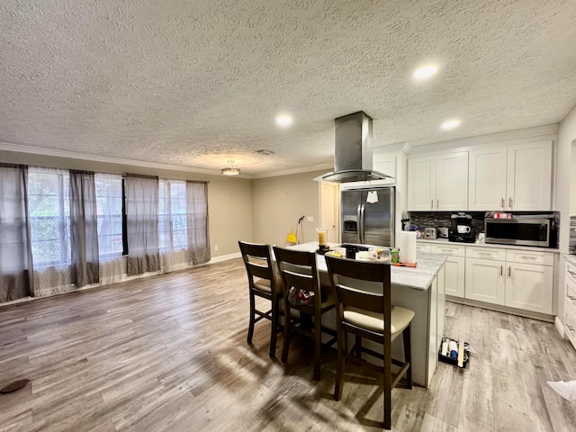 interior space featuring crown molding, a textured ceiling, and light hardwood / wood-style floors