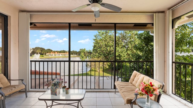 sunroom / solarium with a water view and ceiling fan