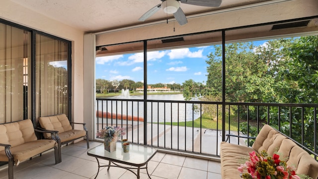 sunroom / solarium featuring a water view and ceiling fan