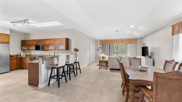 tiled dining room featuring a skylight