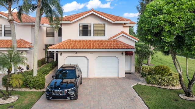 mediterranean / spanish house with a garage and a front lawn